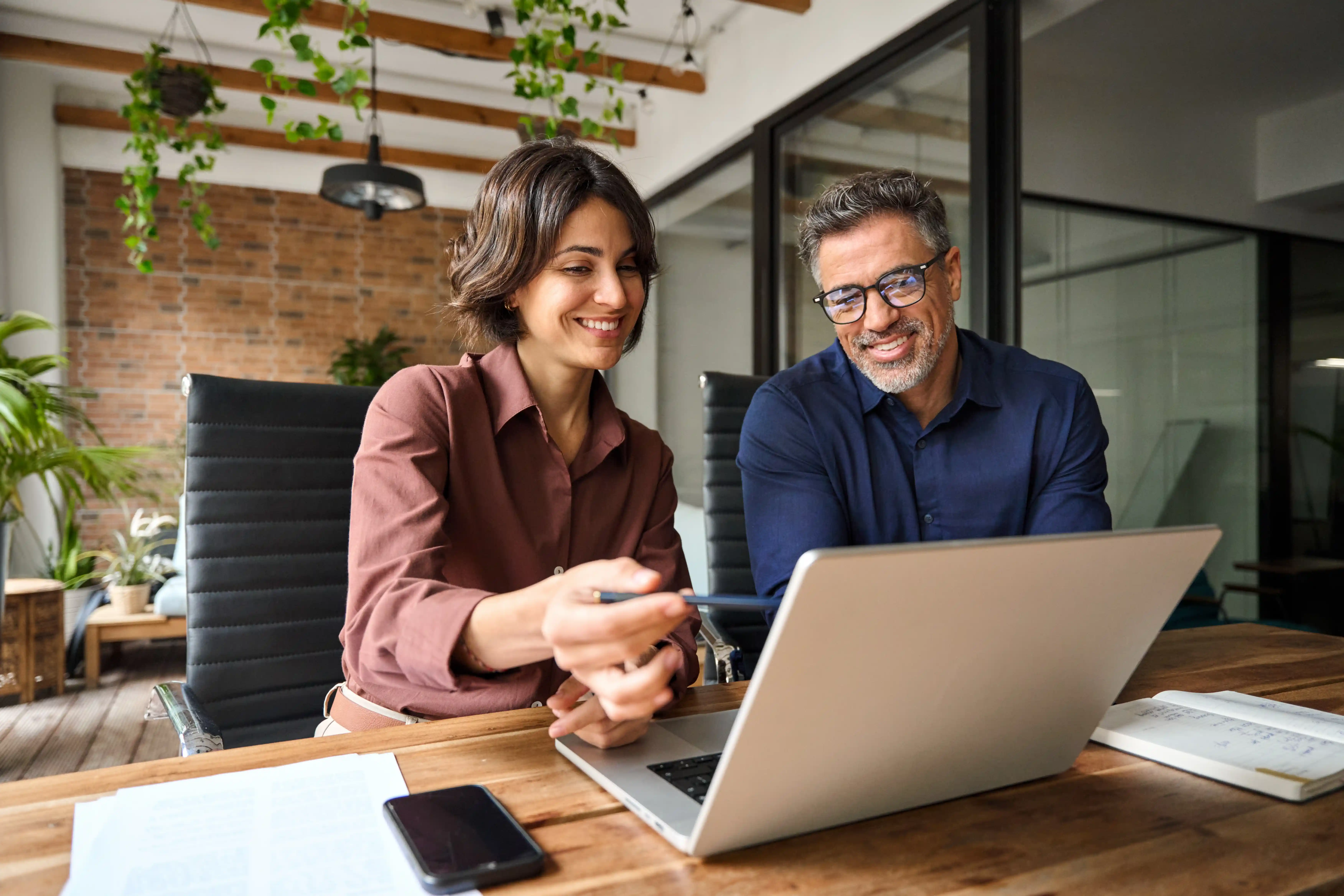 Frau und Mann sitzen im Büro am Laptop